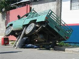 Man under truck on 2x4 board.jpg Man under truck on 2x4 board.jpg