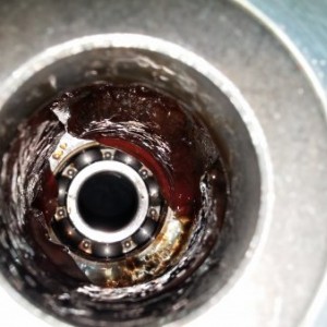 Steering column pinion housing with bottom bearing
