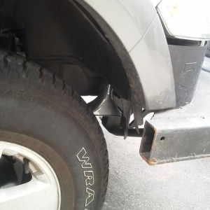 Bottom of airhorn peeking out in wheel well.  Will easily clear a 35 in tire where it is, although the rest of the truck may not... lol